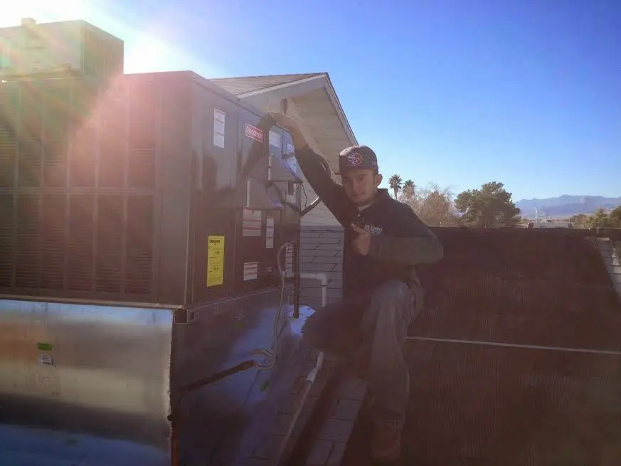 HVAC technician performing Air Duct Repair on a rooftop unit in Savage